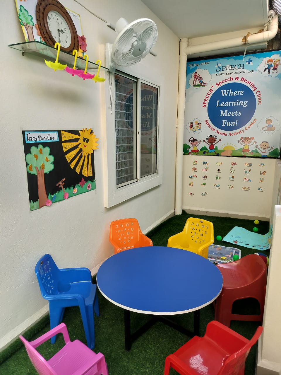Blue classroom table and colorful child-sized chairs used for therapy tasks